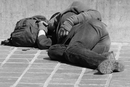Ein Schlafender Obdachloser liegt in einer Fussgängerzone